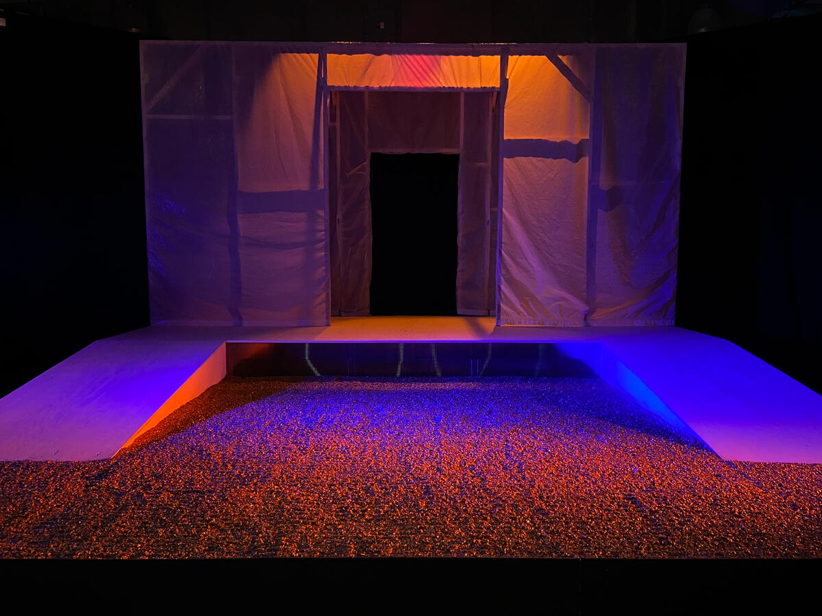 A dimly lit stage covered in vermiculite.